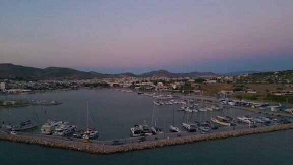 航拍50便士的镜头拍摄了夏天日落时分希腊爱琴海萨拉米斯岛的海滩上的船只和游艇