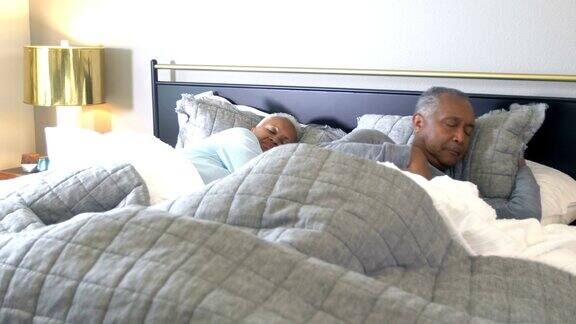 一对老非裔美国夫妇在床上睡觉