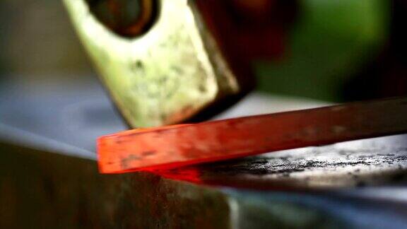 在铁匠中锻造热金属铁匠在铁砧上手工锻造热金属