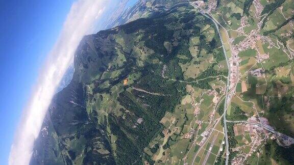 穿着翼装的飞行者在瑞士的山景上翱翔