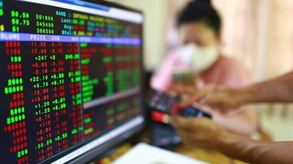 证券交易市场业务智能手机上显示的股票行情用模糊的红色图形病人戴着口罩