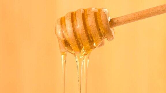 蜂蜜滴从蜂蜜勺倾倒和流动