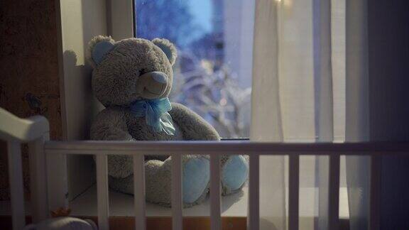 窗外飘着雪花婴儿床和玩具熊