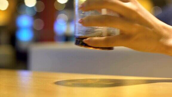 女人手指伸向桌上的饮料杯快餐消费主义?
