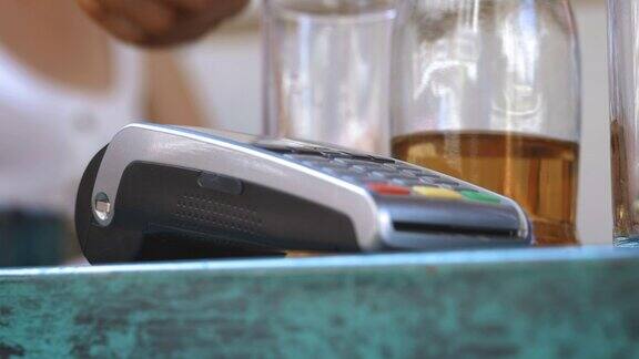 NFC信用卡支付男性顾客用非接触式信用卡支付采用NFC技术电子货币的银行业务无线金钱交易无线支付