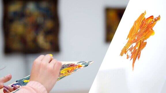 女艺术家开始在画布上画一幅画美术馆的背景4k