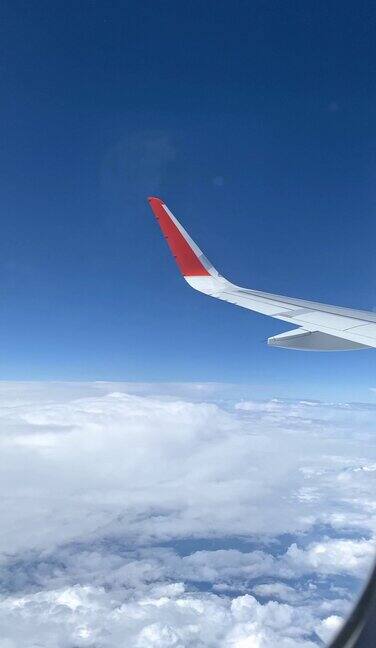 从飞机窗口看到的云朵和飞机的机翼