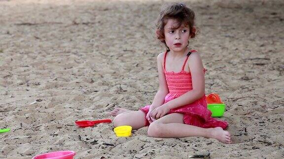 伤心的小女孩从手里倒沙子