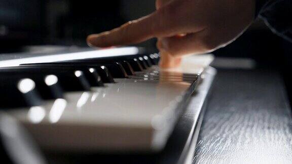 钢琴家的手指按合成器的键在录音室工作男性弹奏钢琴的手侧视慢动作特写