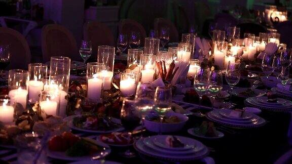 装饰蜡烛在餐桌上眼镜和圣诞蜡烛在桌子上白色蜡烛与玻璃烛台蜡烛与玻璃烛台餐厅室内特写