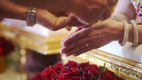 传统的泰国订婚或婚礼由手新娘接受圣水从一个金色的海螺壳