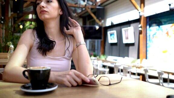一个沮丧的女人独自坐在café上发短信