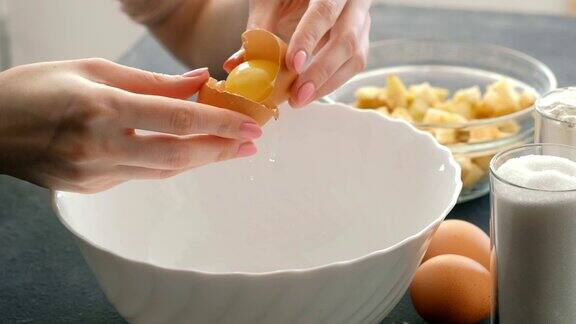 特写女子的手打破鸡蛋和分离蛋白从蛋黄