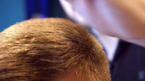 一个年轻人在理发店里给他的男顾客理发弄头发的过程顶部视图