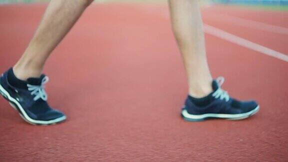 穿着跑鞋在跑道上行走的运动员