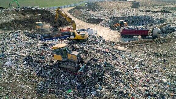 城市垃圾场推土机沿着垃圾填埋场移动铲平垃圾鸟瞰图