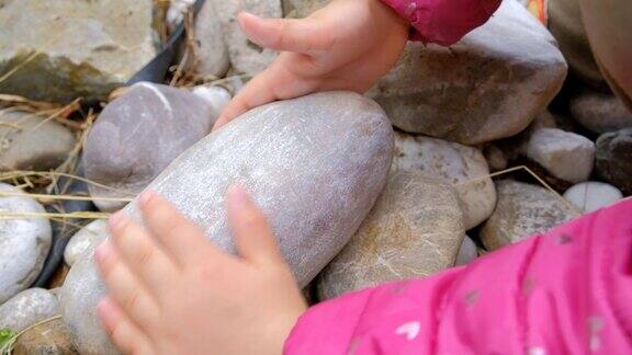 孩子用一块石头摩擦另一块石头的特写