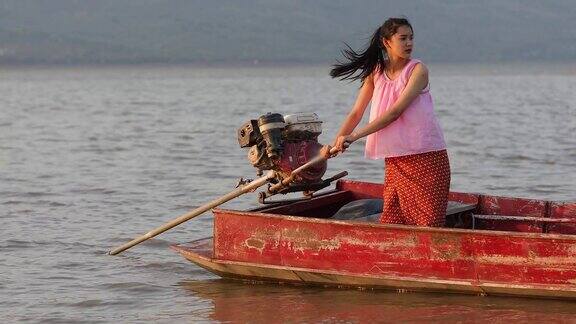 亚洲女渔民正在驾驶一艘船捕鱼