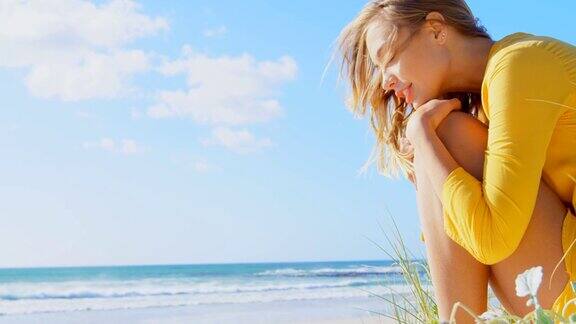 侧面的年轻白人妇女在海滩上放松4k