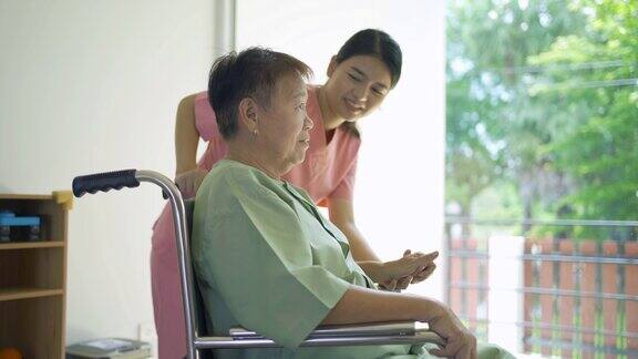 护士正在检查坐在轮椅上病人的身体