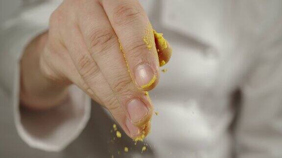 特写:厨师在烹饪时撒上黄色姜黄粉-慢镜头