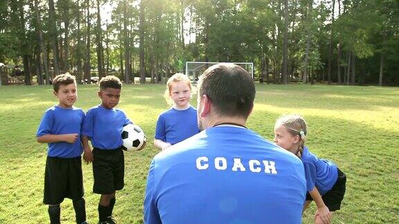 多民族儿童在足球队听教练讲课