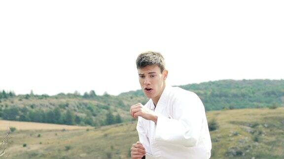 青年运动员在大自然中练习跆拳道艺术慢慢地