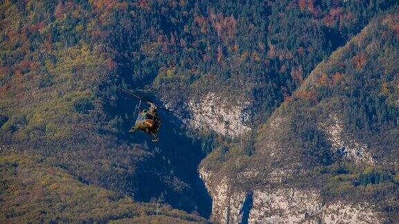 一架军用直升机飞过树林