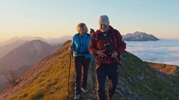 一对老年徒步旅行者在山脊上行走