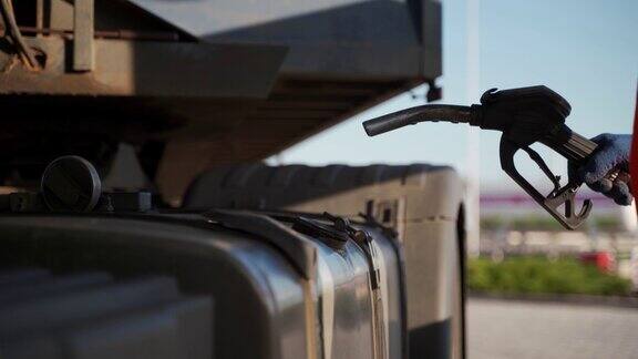 卡车司机在加油站用柴油加注枪给油箱加油燃油价格不断飙升、经济问题卡车司机给卡车加油