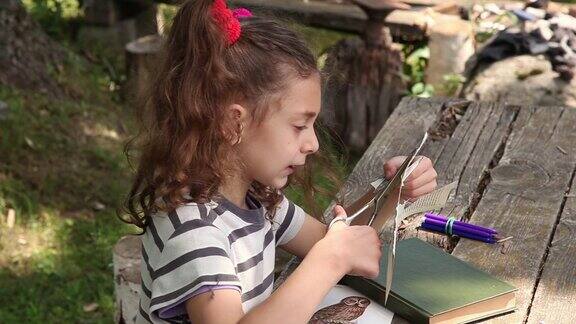 一个小女孩在后院剪纸做贴花的侧视图