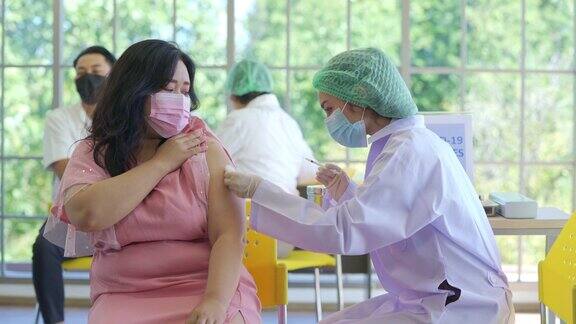 为了预防新冠病毒医生在医院给一名肥胖女性注射新冠病毒疫苗