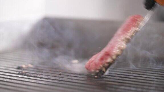 一个汉堡肉在烤架上煎的特写