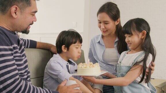 亚洲男孩惊喜生日蛋糕和庆祝派对与家人