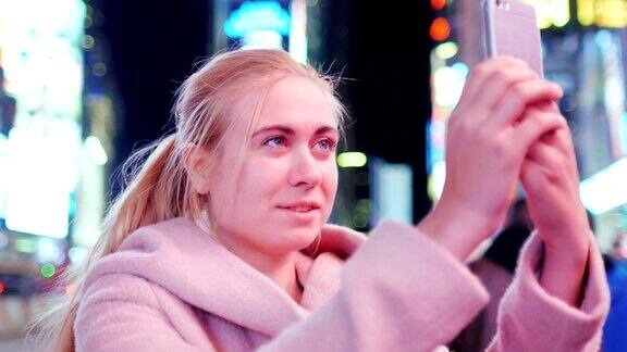 一名女游客在纽约著名的时代广场上用手机拍照