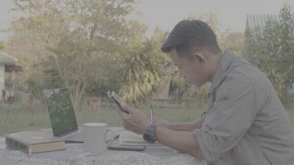 亚洲学生在家里的前院用平板电脑和笔记本电脑在线学习年轻人用绿色屏幕触摸平板电脑进行在线学习