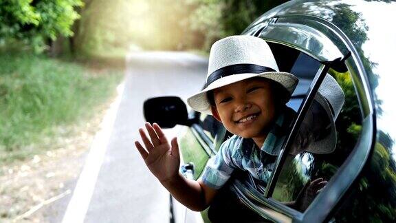 快乐的亚洲男孩正在招手乘车旅行公路旅游