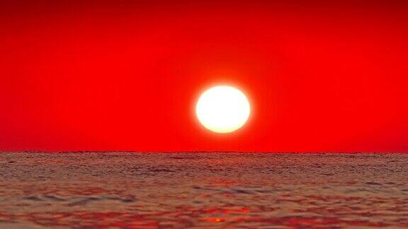 巨大的太阳在海面上落下红色的天空慢镜头4k
