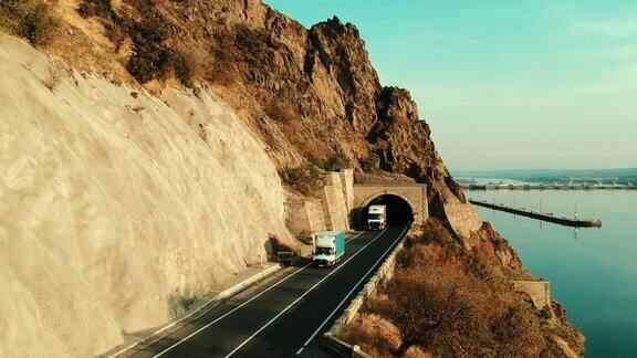 无人机拍摄的道路交通汽车进出穿越这座山的隧道