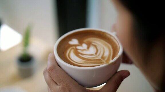 手捧咖啡的女人在咖啡厅喝咖啡慢镜头