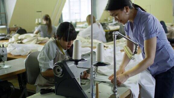 女裁缝在缝纫厂帮助同事