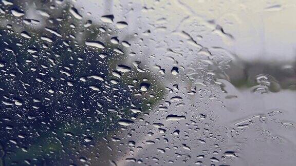 透过汽车挡风玻璃看路有雨滴在雨中行驶