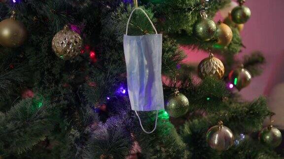 疫情期间的新年晚会医疗防护口罩和闪烁花环的球晚上挂在温馨的家里的圣诞树上
