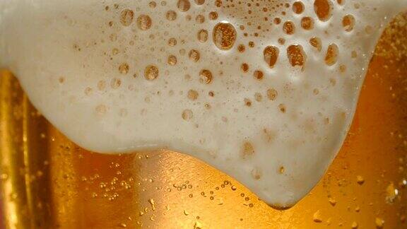 一杯啤酒的特写镜头和泡沫的慢动作