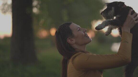 年轻女子在自然中散步手里拿着小猎犬