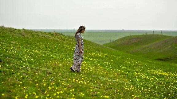 穿着长裙的女人走在田野上