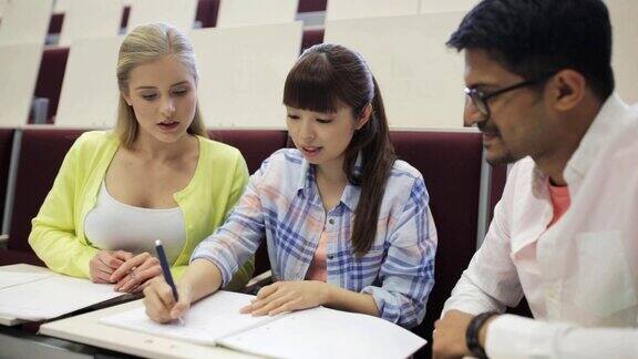 一群学生拿着笔记本在报告厅