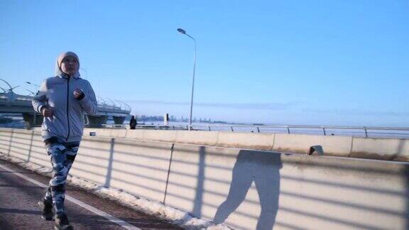 冬天跑步者在跑步机上晨跑经过一座桥