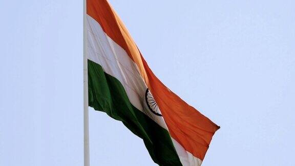 印度国旗在蓝天下高高飘扬印度国旗飘扬印度国旗在独立日和印度共和国日倾斜拍摄挥舞印度国旗飘扬印度国旗