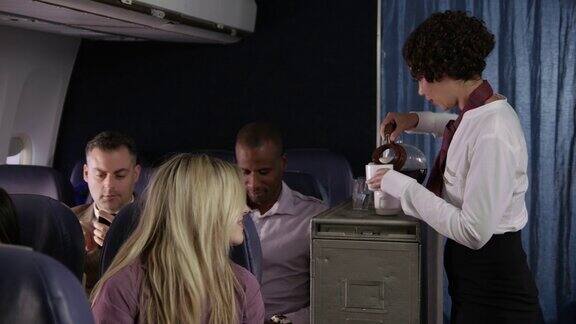 乘务员为飞机乘客提供饮料